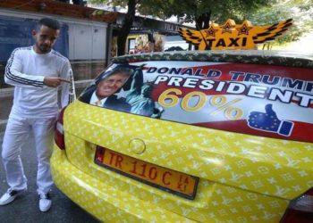 Uljan Kolgjegja, 37, an Albanian taxi driver, points to a picture of U.S. Republican candidate Donald Trump in his car in the Albanian capital, Tirana, Monday, Sept. 26, 2016.